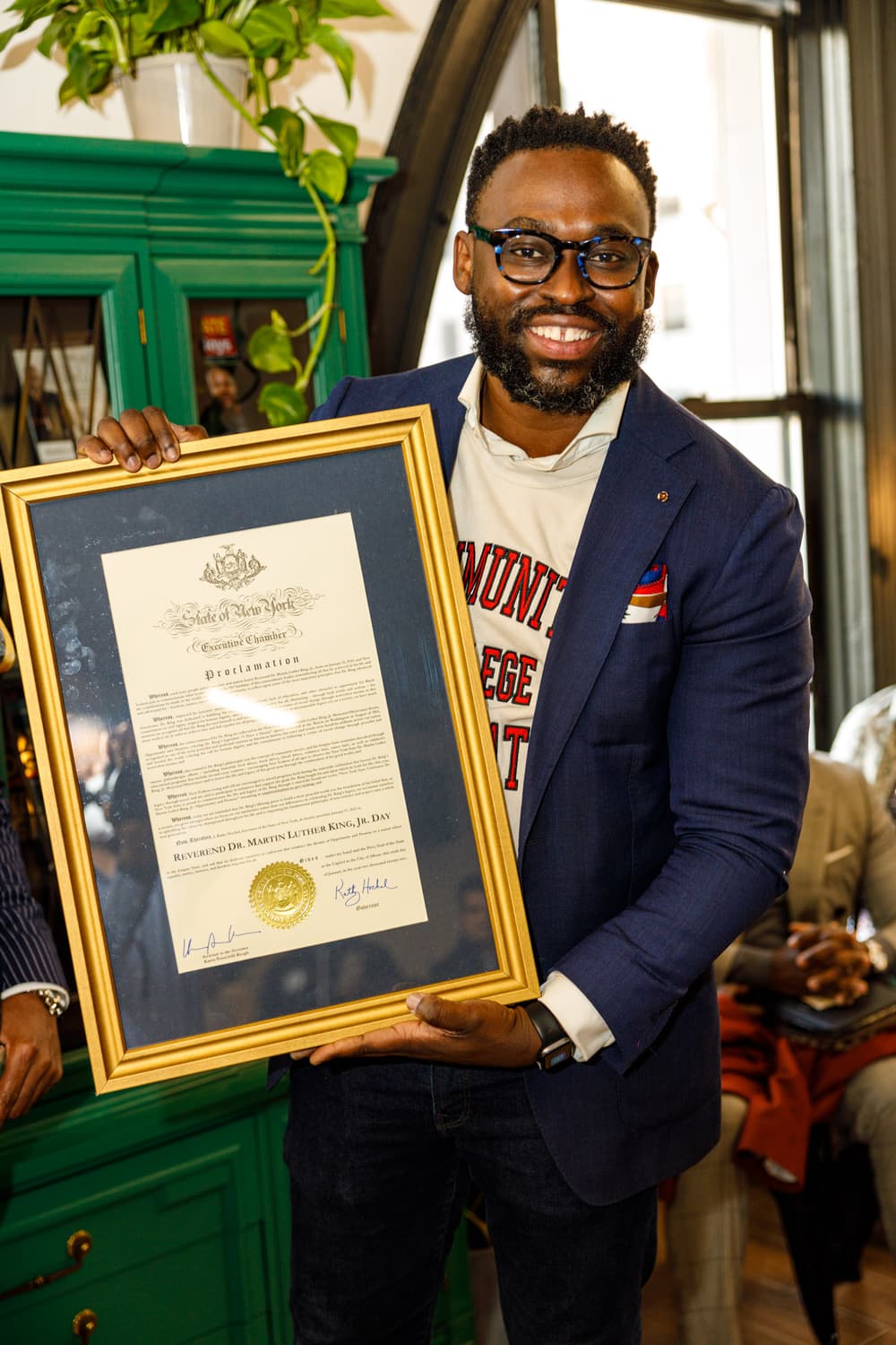 Holding a framed New York State proclamation.